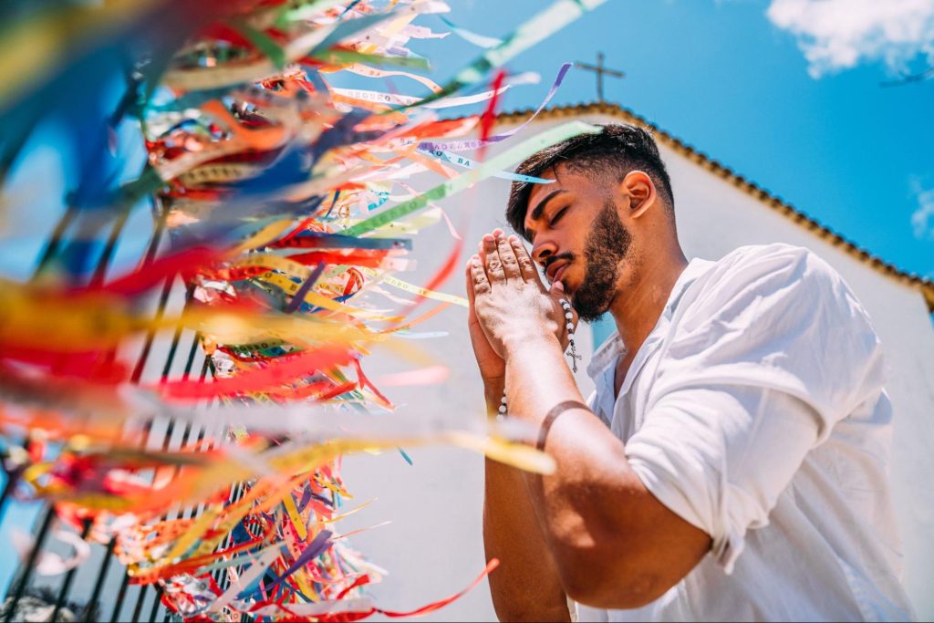 Turista faz oração perto de Igreja em Arraial d'Ajuda, Bahia. Imagem ilustrativa para post sobre o que fazer em Arraial d'Ajuda, da Soma Urbanismo.